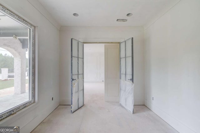 unfurnished room featuring healthy amount of natural light and arched walkways
