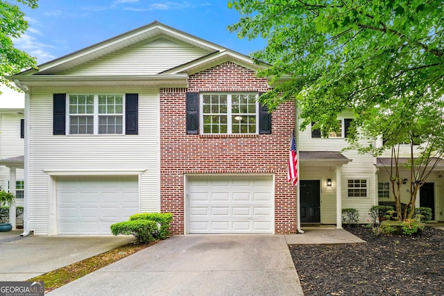 view of front of home with driveway, an attached garage, and brick siding