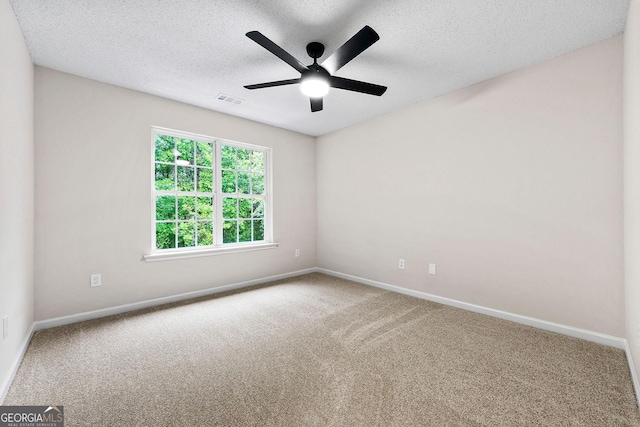 spare room featuring carpet, baseboards, ceiling fan, and a textured ceiling