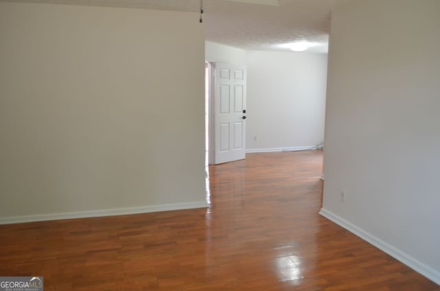 corridor with wood finished floors and baseboards