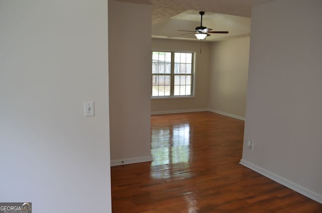 spare room featuring ceiling fan, wood finished floors, and baseboards