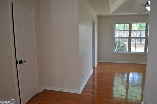 hallway featuring wood finished floors and baseboards