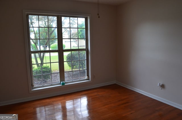 unfurnished room featuring baseboards and wood finished floors