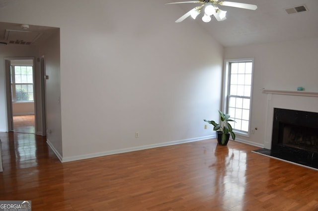 unfurnished living room featuring ceiling fan, plenty of natural light, wood finished floors, and high vaulted ceiling