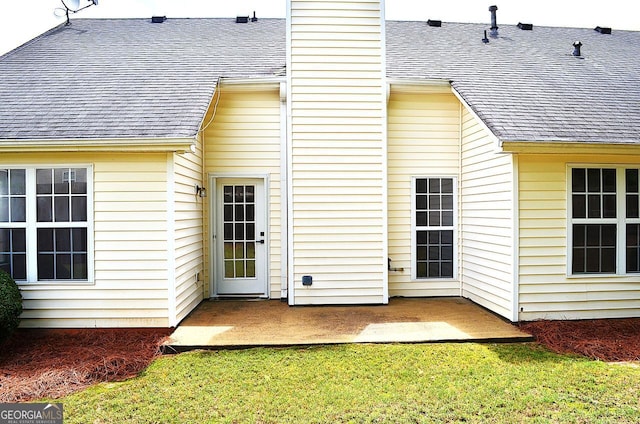 282 Ellesmere Ct, Buford, GA 30518 - back of house with roof with shingles, a chimney, a lawn, and a patio