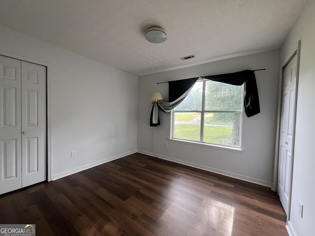 unfurnished bedroom with dark wood-style floors and baseboards