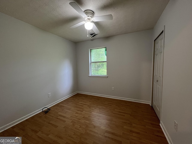 unfurnished bedroom featuring wood finished floors, baseboards, a textured ceiling, and ceiling fan