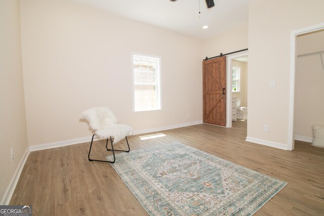 346 Grant Ave, Macon, GA 31201 - unfurnished room featuring a barn door, ceiling fan, plenty of natural light, and wood finished floors