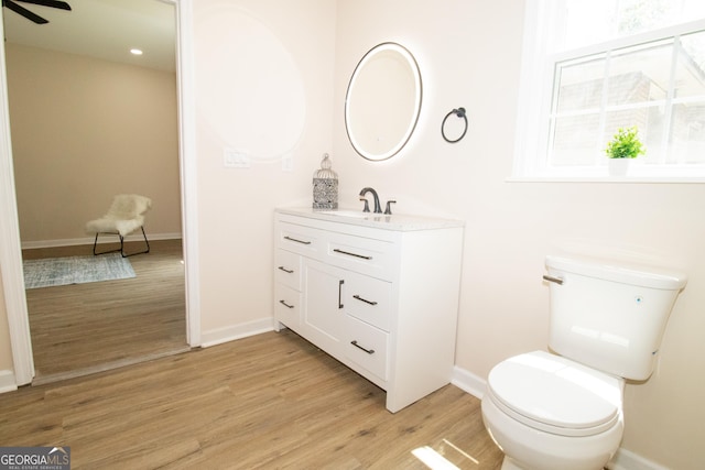346 Grant Ave, Macon, GA 31201 - bathroom featuring wood finished floors, toilet, baseboards, vanity, and ceiling fan