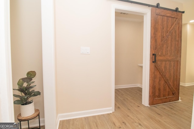 346 Grant Ave, Macon, GA 31201 - hall featuring a barn door, light wood-style flooring, and baseboards