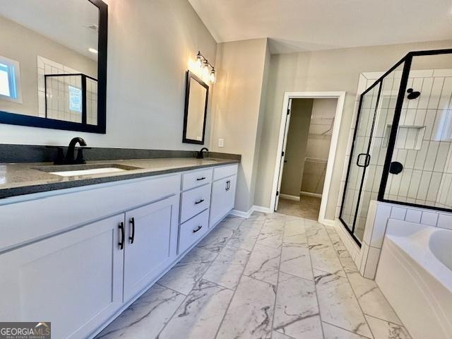 full bathroom featuring marble look tiles, a stall shower, baseboards, a bath, and double vanity