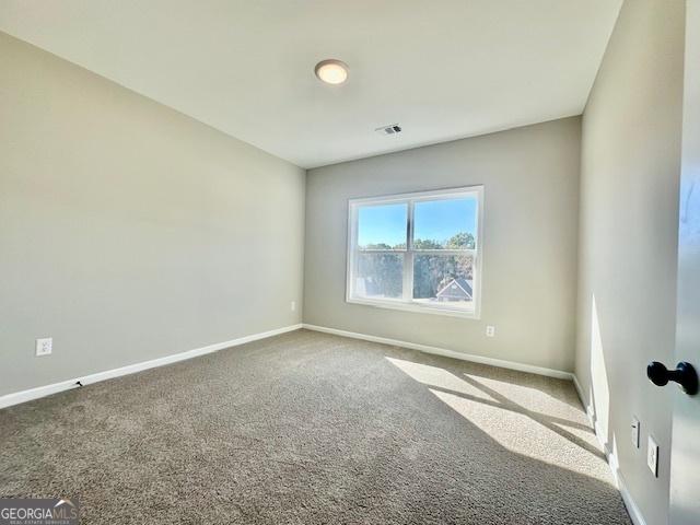 carpeted empty room with baseboards
