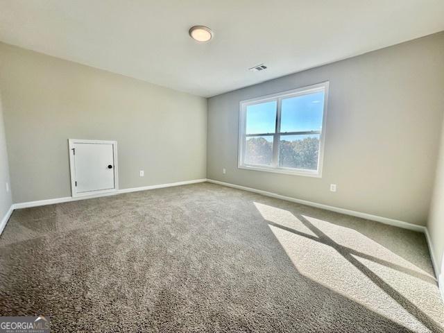 spare room featuring baseboards and carpet floors