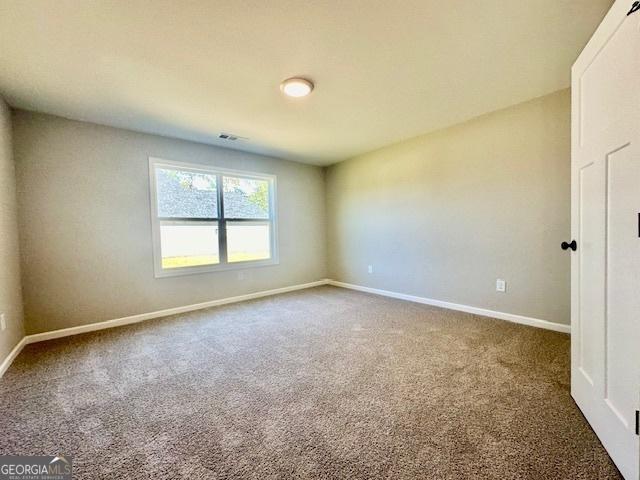 carpeted spare room with baseboards