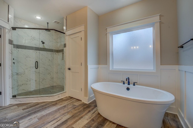 141G Lake Pines Rd, Jackson, GA 30233 - bathroom with a freestanding tub, a marble finish shower, a decorative wall, a wainscoted wall, and wood finished floors