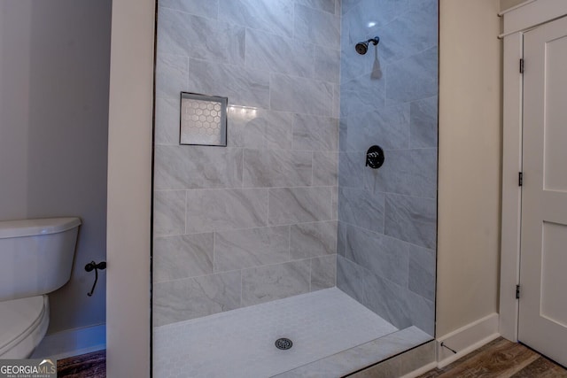 141G Lake Pines Rd, Jackson, GA 30233 - bathroom with toilet, tiled shower, baseboards, and wood finished floors
