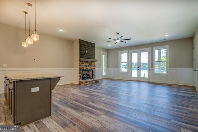 141G Lake Pines Rd, Jackson, GA 30233 - unfurnished living room with a wainscoted wall, ceiling fan, a decorative wall, a fireplace, and dark wood-style flooring