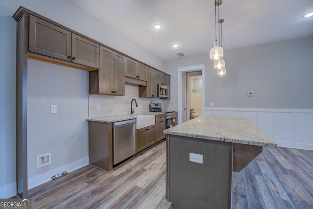 141G Lake Pines Rd, Jackson, GA 30233 - kitchen featuring appliances with stainless steel finishes, a sink, wood finished floors, a kitchen island, and backsplash