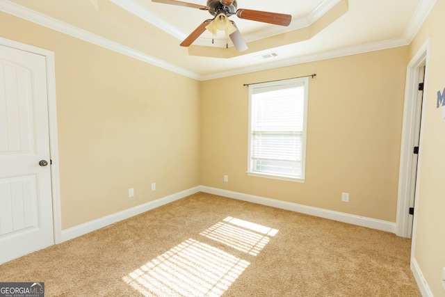 unfurnished bedroom with a tray ceiling, carpet flooring, ornamental molding, baseboards, and a ceiling fan