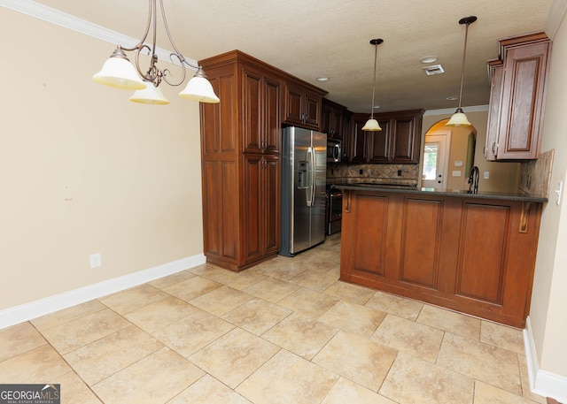 kitchen featuring appliances with stainless steel finishes, dark countertops, baseboards, arched walkways, and a peninsula