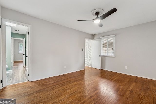 unfurnished bedroom featuring wood finished floors, baseboards, and ceiling fan