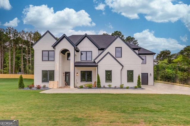 french country home featuring a front lawn, driveway, and board and batten siding