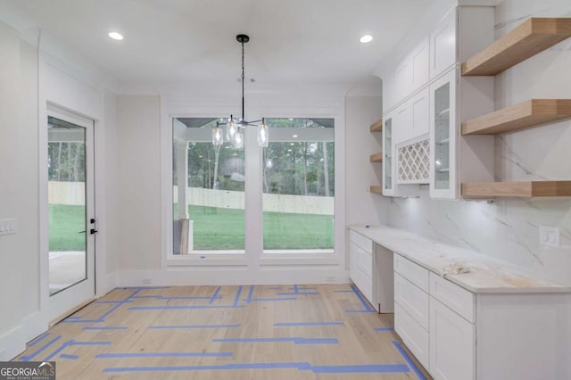 unfurnished dining area with a chandelier, light wood-style flooring, and recessed lighting