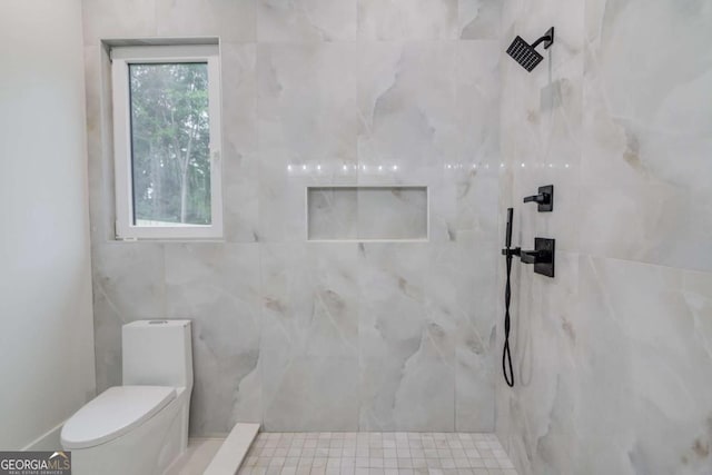 bathroom with a marble finish shower and toilet