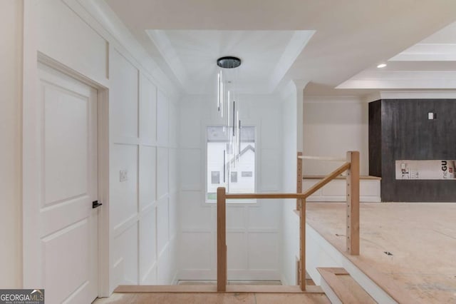 hall featuring a decorative wall, a tray ceiling, and recessed lighting