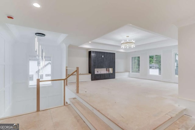 entryway with a raised ceiling, a chandelier, and recessed lighting