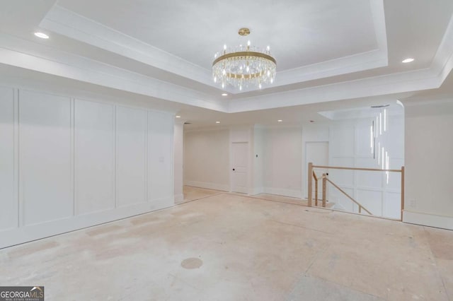 spare room featuring a tray ceiling, recessed lighting, crown molding, a chandelier, and baseboards
