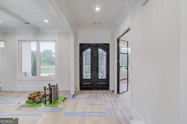foyer entrance with french doors, ornamental molding, recessed lighting, wood finished floors, and baseboards