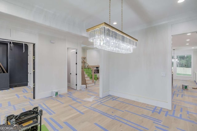 unfurnished dining area with a chandelier, stairway, recessed lighting, and baseboards