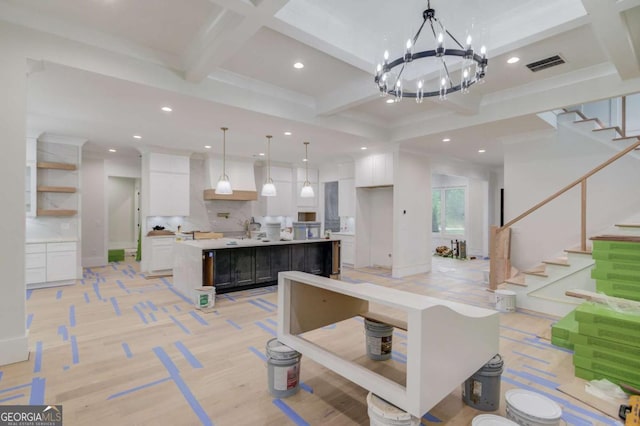 kitchen featuring open shelves, a spacious island, white cabinets, coffered ceiling, and light countertops
