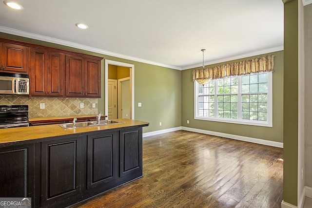 kitchen featuring stainless steel microwave, electric stove, a sink, baseboards, and crown molding