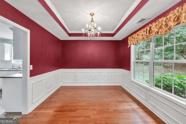 272 Blackberry Ln, Pendergrass, GA 30567 - unfurnished dining area featuring a tray ceiling, a chandelier, light wood-style floors, wainscoting, and ornamental molding