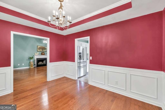 272 Blackberry Ln, Pendergrass, GA 30567 - spare room with a chandelier, a fireplace, wainscoting, ornamental molding, and wood finished floors