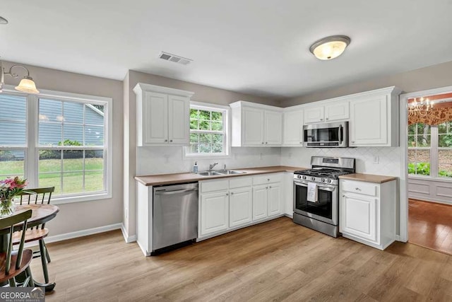 272 Blackberry Ln, Pendergrass, GA 30567 - kitchen featuring stainless steel appliances, decorative backsplash, white cabinets, and light wood-type flooring