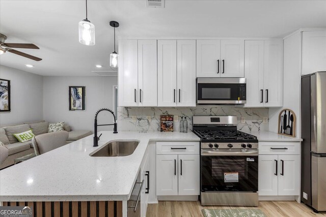 4134 Burgess Dr, Decatur, GA 30035 - kitchen with appliances with stainless steel finishes, a sink, open floor plan, light wood-style flooring, and recessed lighting