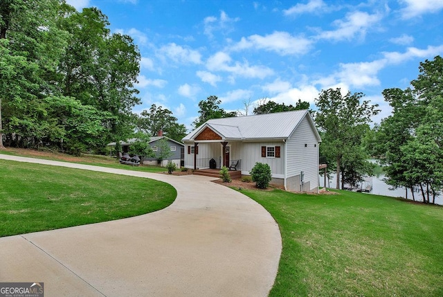 view of front of property featuring board and batten siding, a front yard, and curved driveway