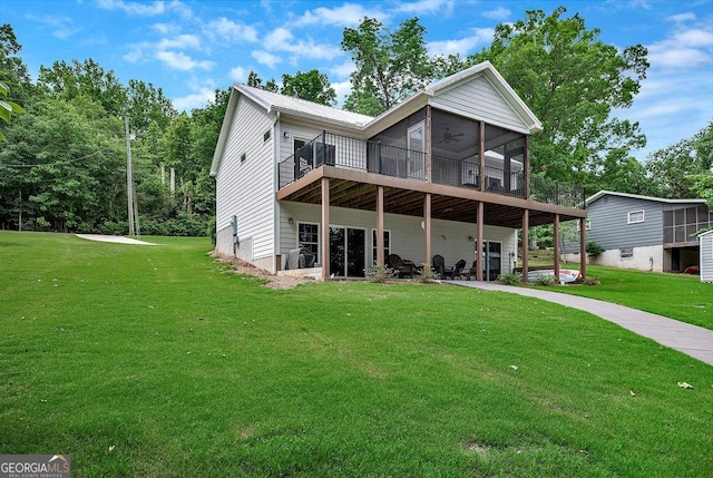 back of house with a yard, a deck, and a sunroom