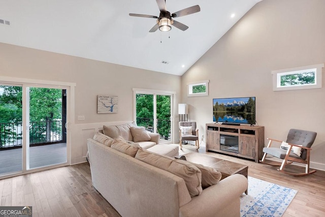 living room with high vaulted ceiling, wood finished floors, ceiling fan, healthy amount of natural light, and recessed lighting