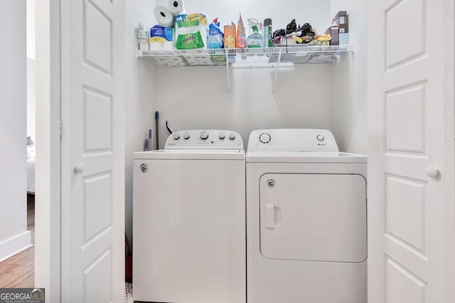 washroom with washer and clothes dryer and wood finished floors
