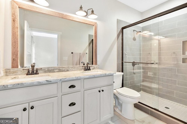 full bathroom featuring a stall shower, toilet, double vanity, and tile patterned floors