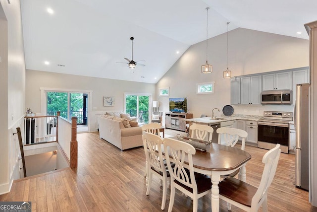 dining area featuring a ceiling fan, high vaulted ceiling, light wood-style floors, and recessed lighting