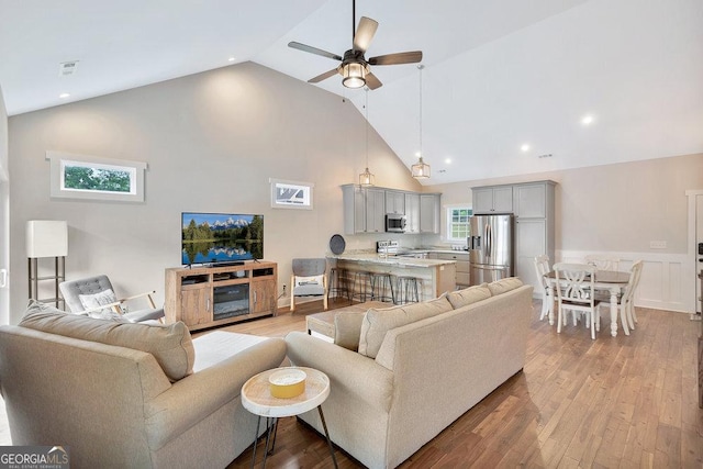 living area with high vaulted ceiling, a ceiling fan, wood finished floors, and recessed lighting