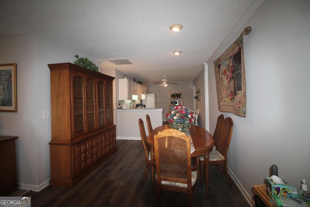 dining space featuring baseboards, dark wood-style flooring, ceiling fan, and a textured ceiling