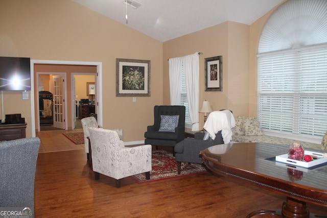 living area with lofted ceiling, wood finished floors, and french doors