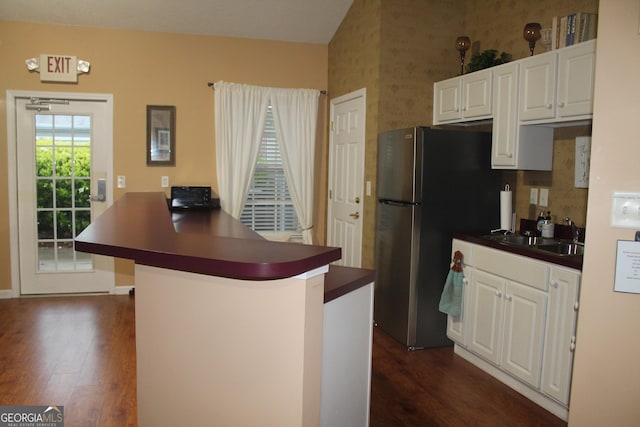 kitchen featuring dark countertops, dark wood-style floors, a peninsula, and white cabinets