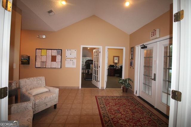 entrance foyer with french doors, lofted ceiling, and tile patterned floors
